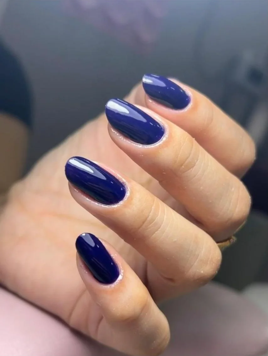 Unhas esmaltadas em azul-marinho